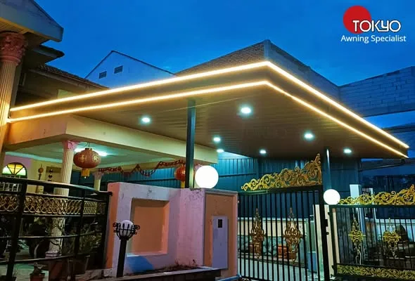 C-roof awning with LED ceiling lighting over a driveway gate at night — real completed project serving the Serdang area