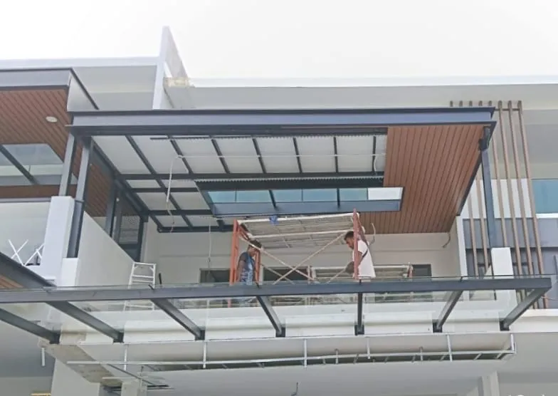 Installation crew fitting roofing panels on an upper-floor balcony canopy